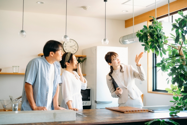 家の中を案内する女性と夫婦